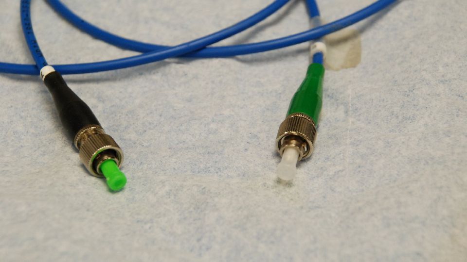 Green APC fibre connector photographed close up