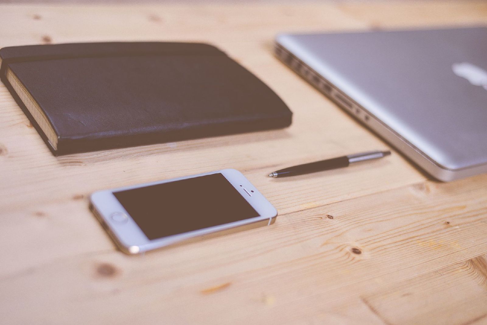 iPhone sitting on a desk beside a laptop